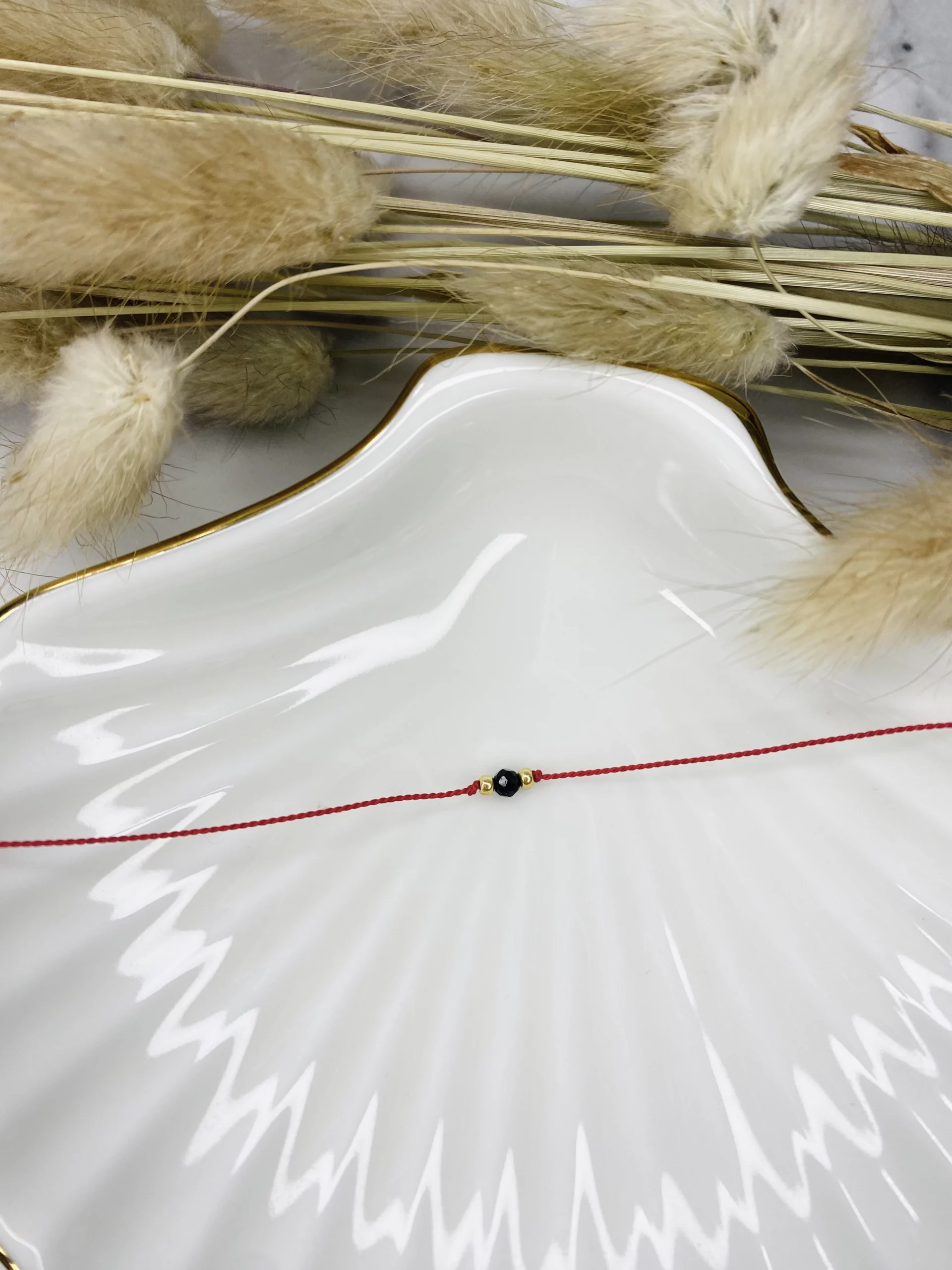 czerwona bransoletka ochronna z turmalinem na białym tle