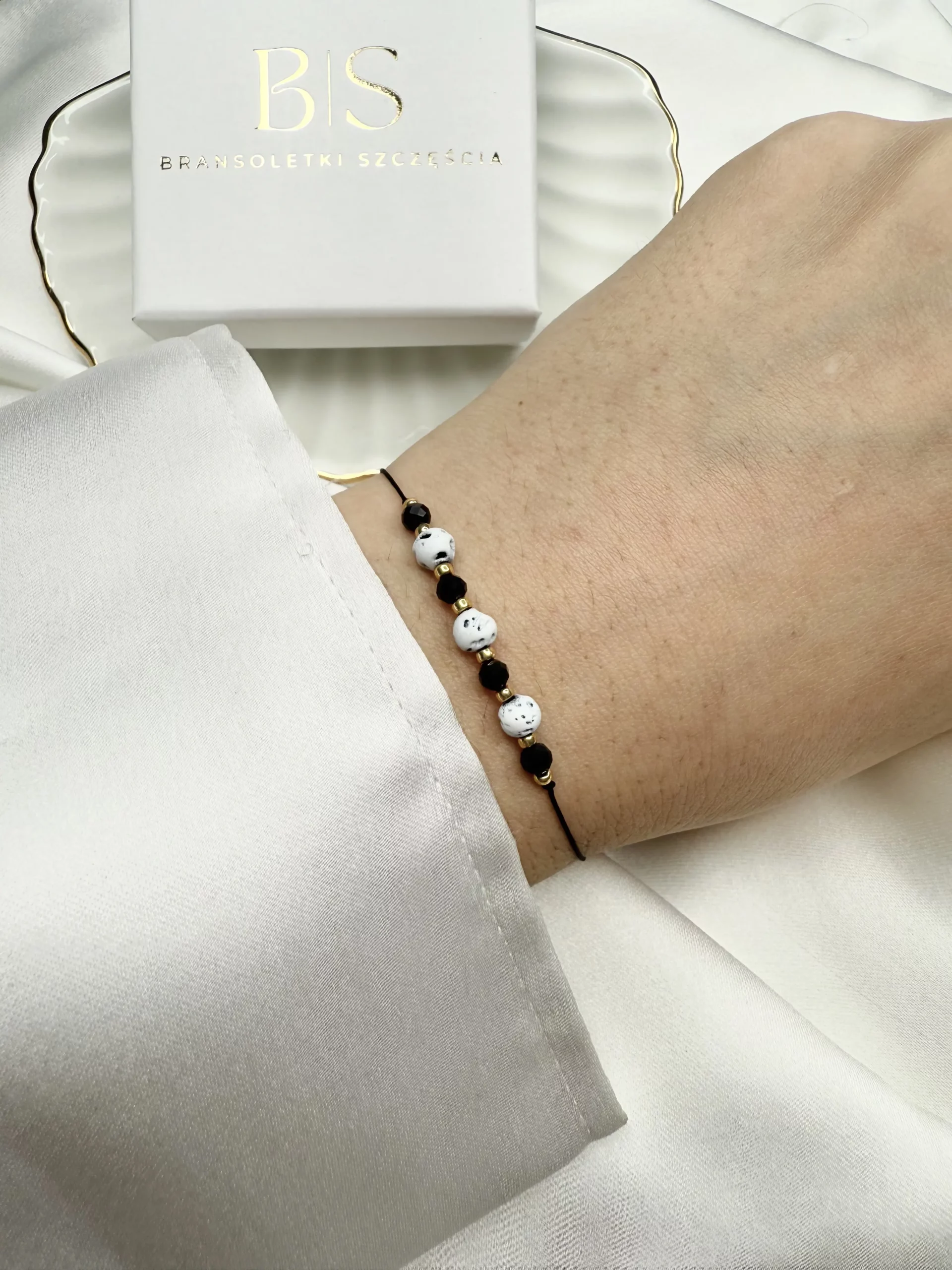 bransoletka na nadgarstku, wykonana z czarnej jedwabnej nici, z naturalnymi kamieniami: lawa wulkaniczna i czarny obsydian, oraz złotymi koralikami