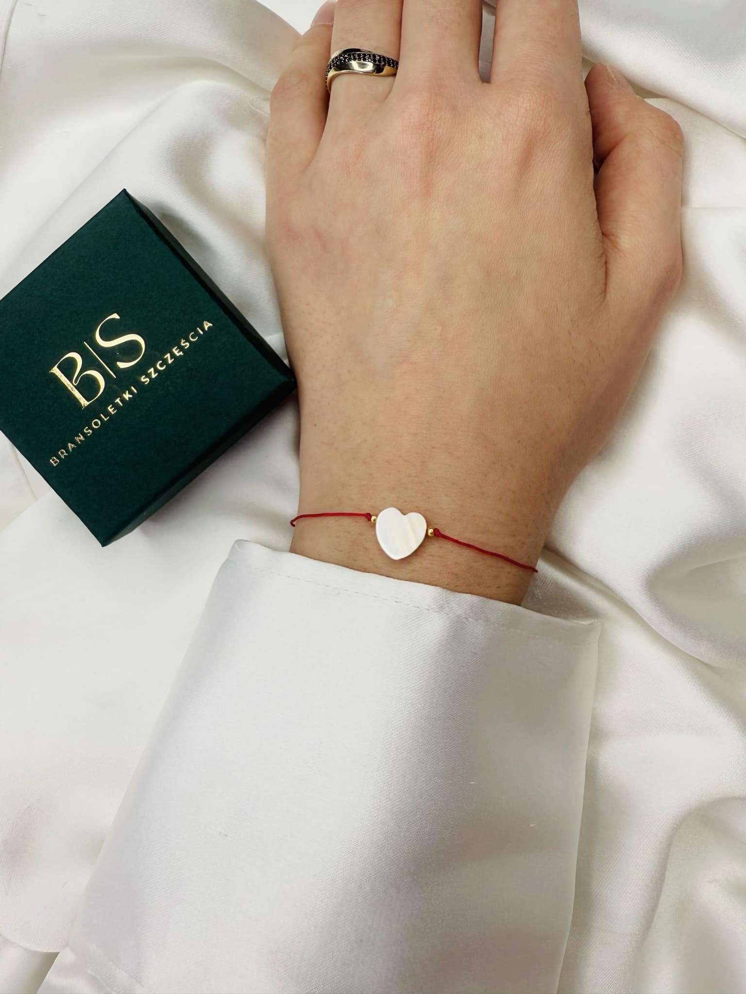 Bransoletka z serduszkiem z masy perłowej na nadgarstku