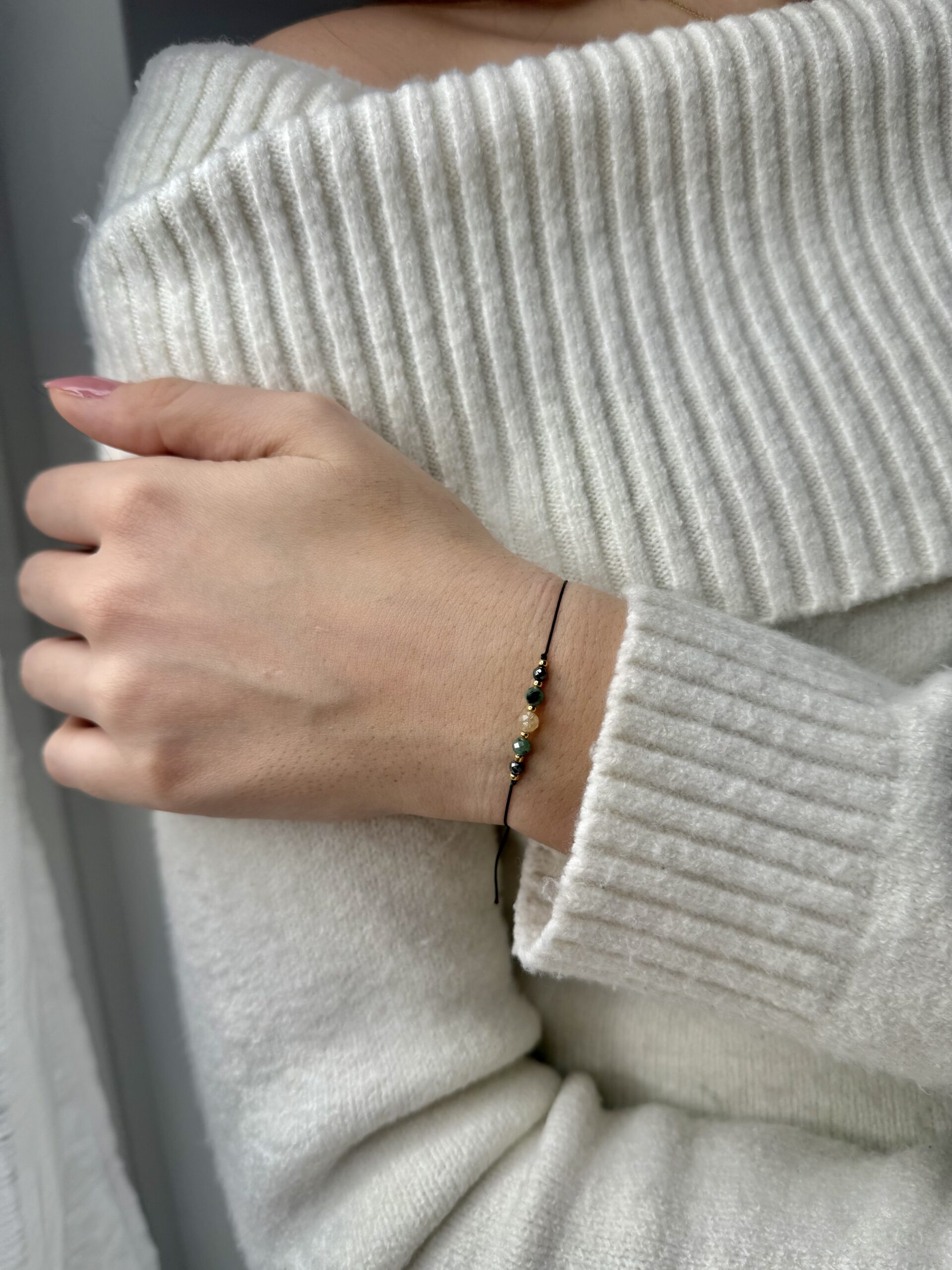 ręcznie robiona bransoletka byk z naturalnymi kamieniami cytryn, szmaragd i hematyt, na nadgarstku z kolekcji zodiakalnej