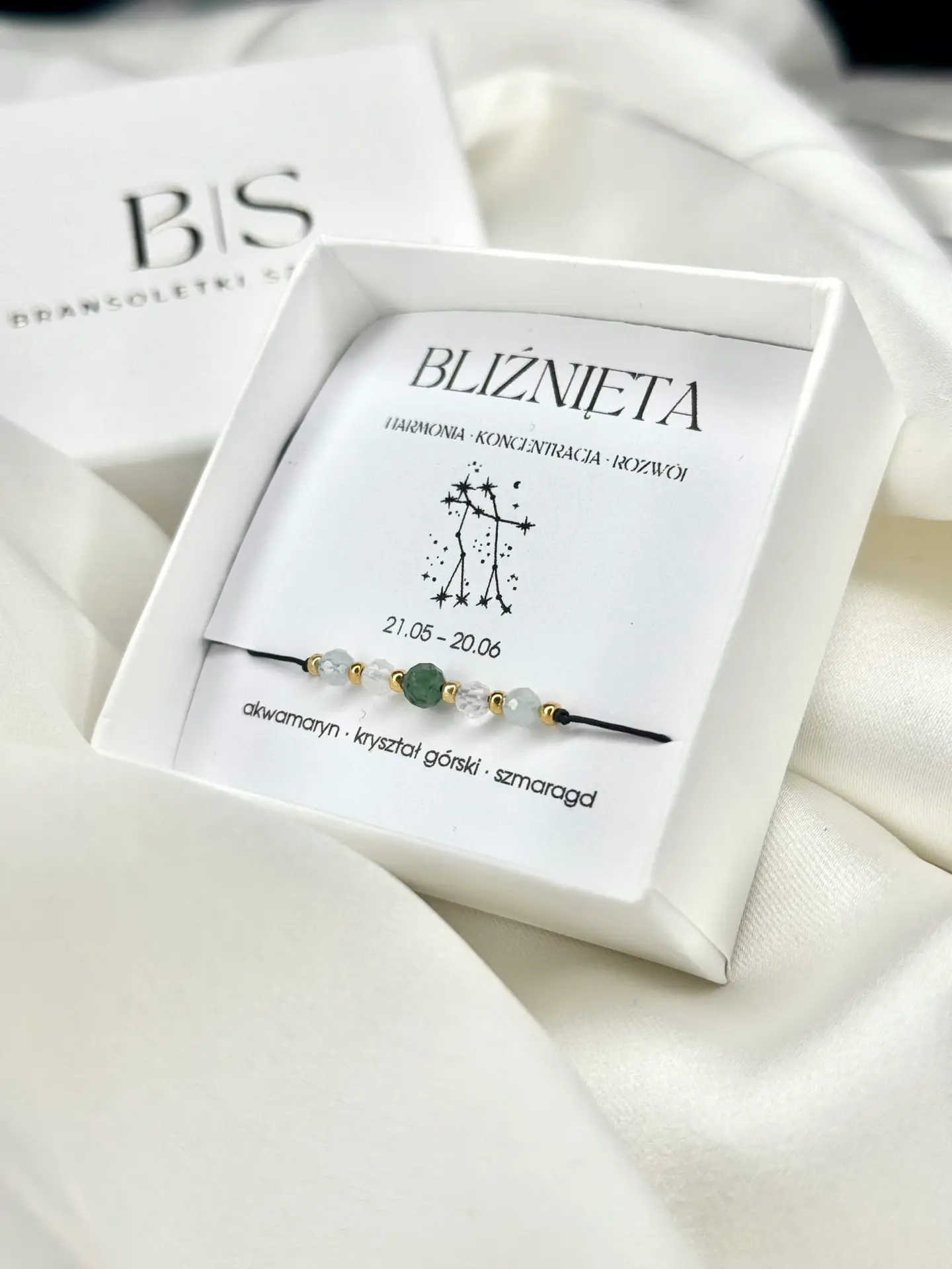 Bransoletka zodiakalna Bliźnięta w białym pudełku prezentowym na białym tle.