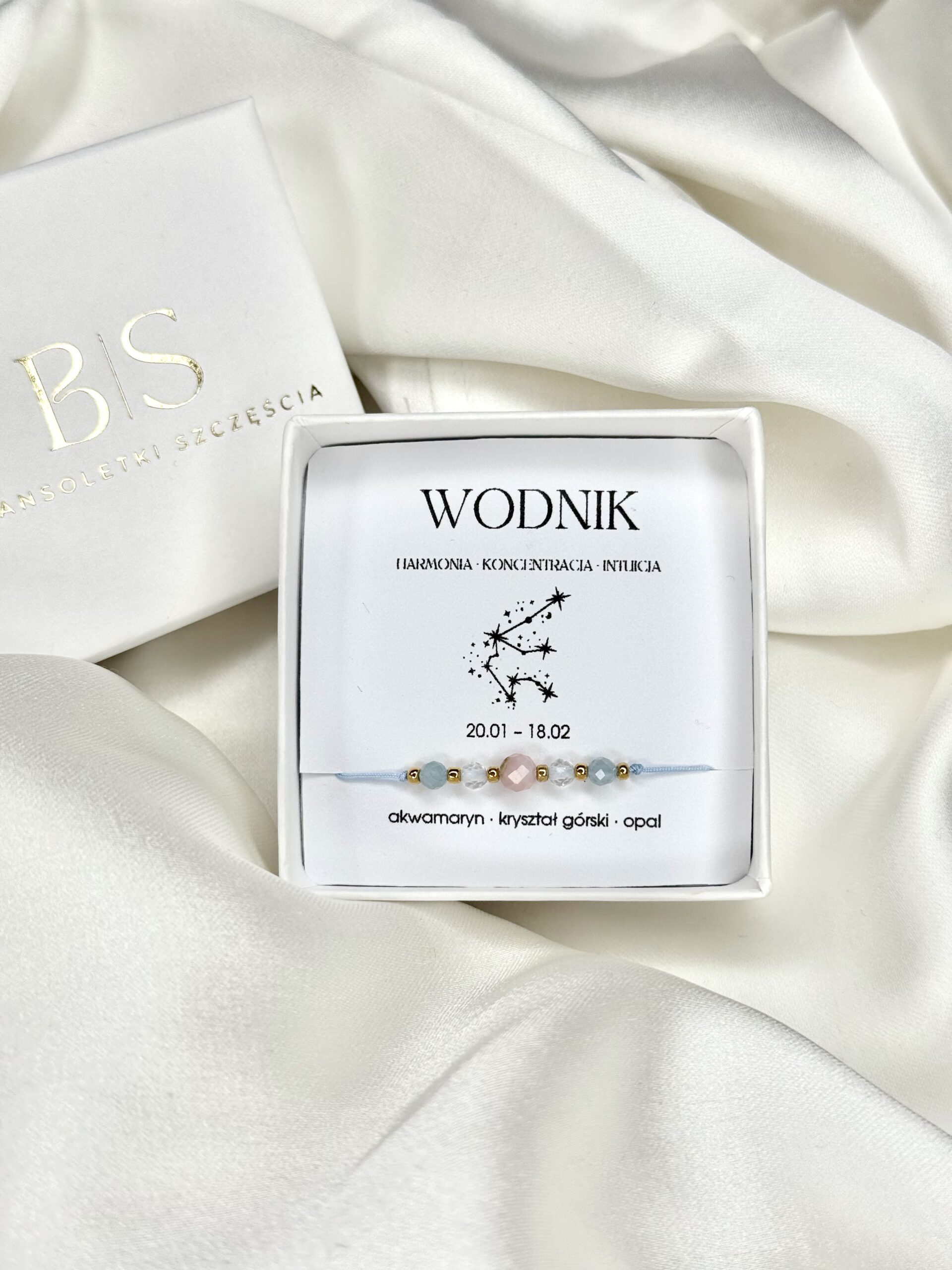 Bransoletka zodiakalna Wodnik w białym pudełku na białym tle.