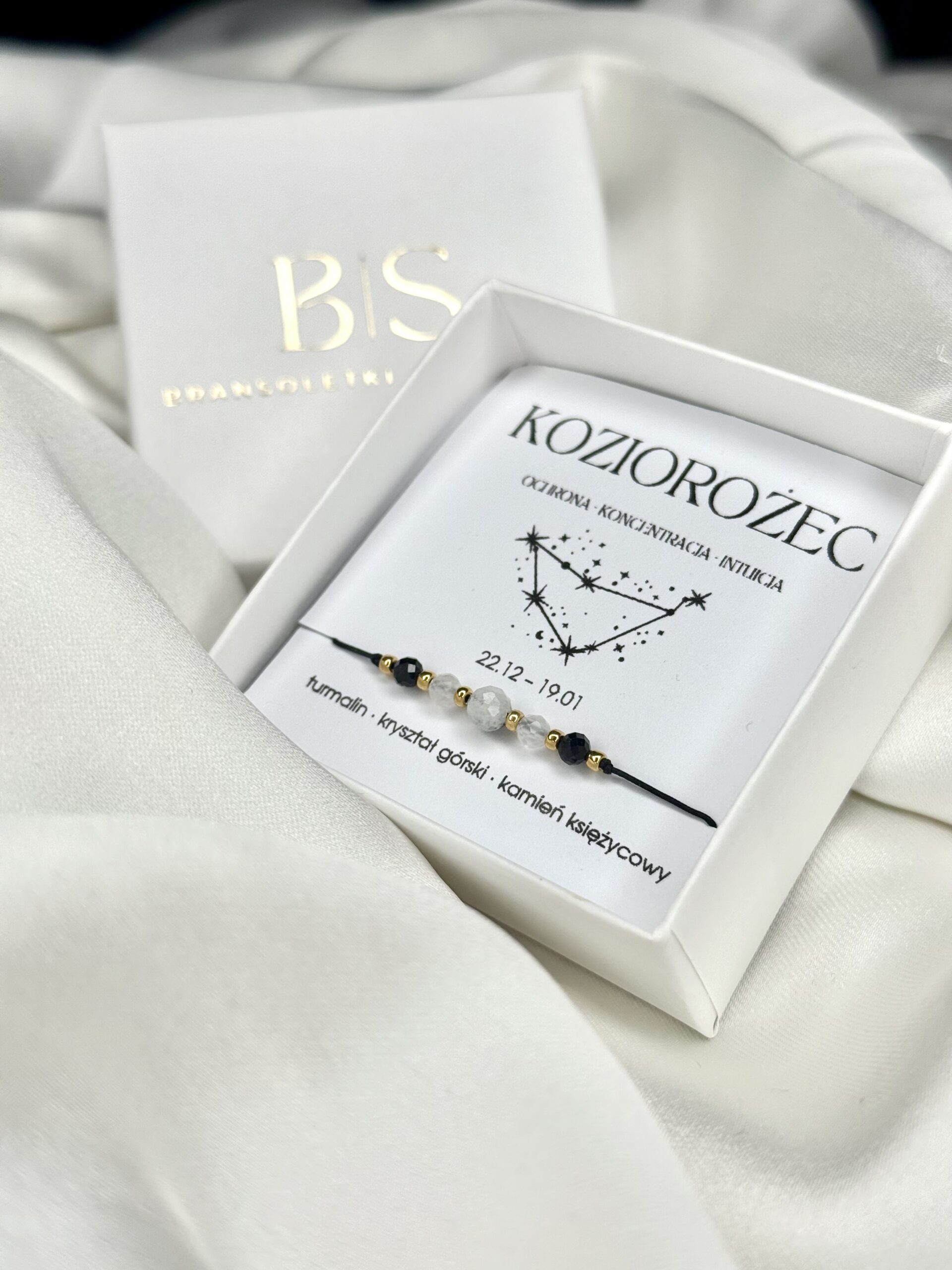 Elegancka bransoletka zodiakalna Koziorożec w białym pudełku na białym tle.
