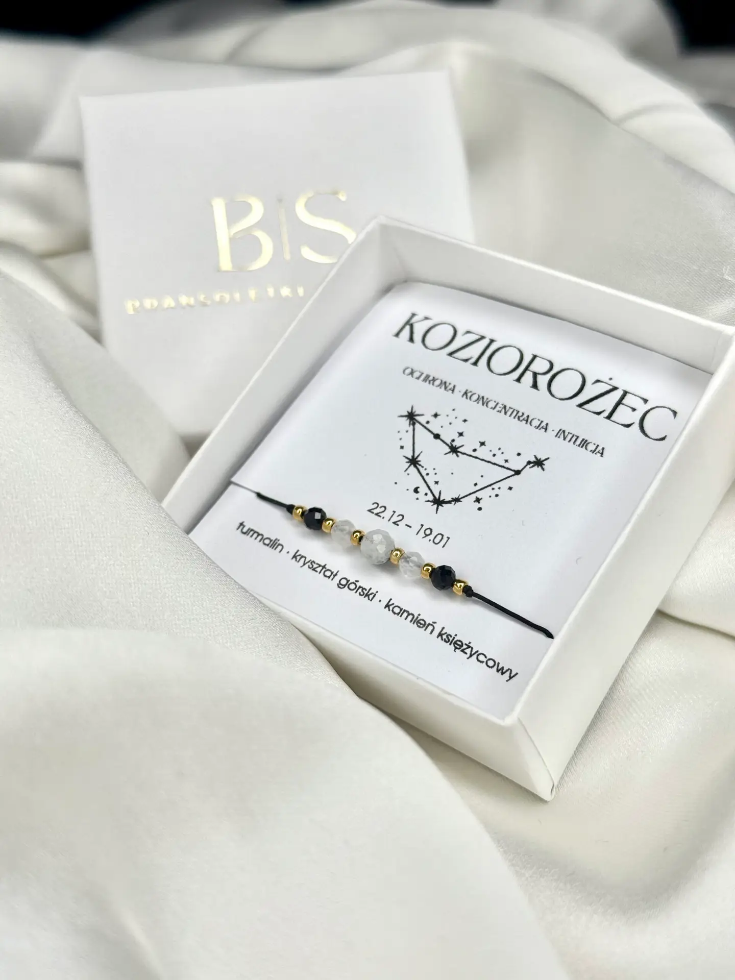 Elegancka bransoletka zodiakalna Koziorożec w białym pudełku na białym tle.